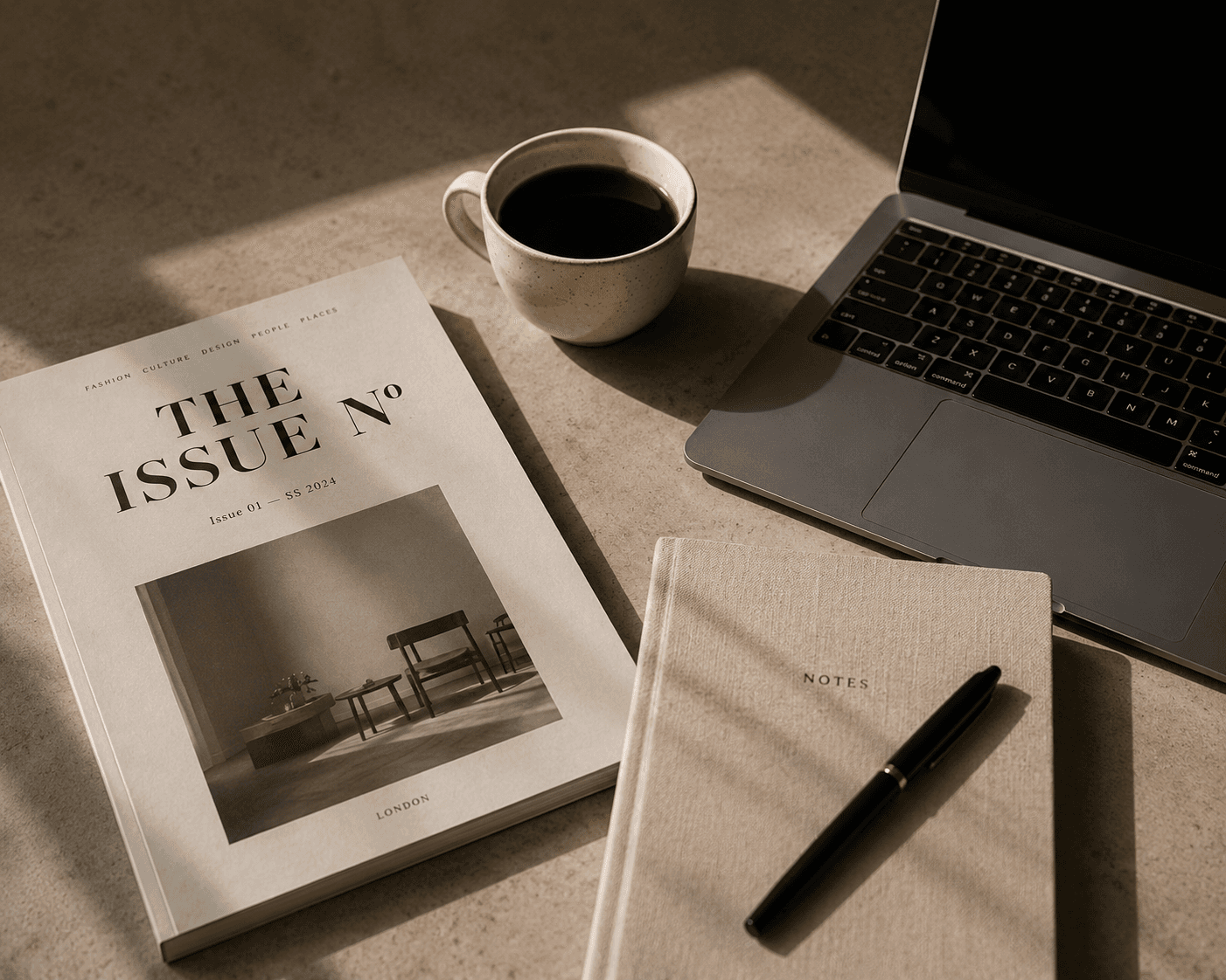The Issue magazine, notebook, laptop and coffee